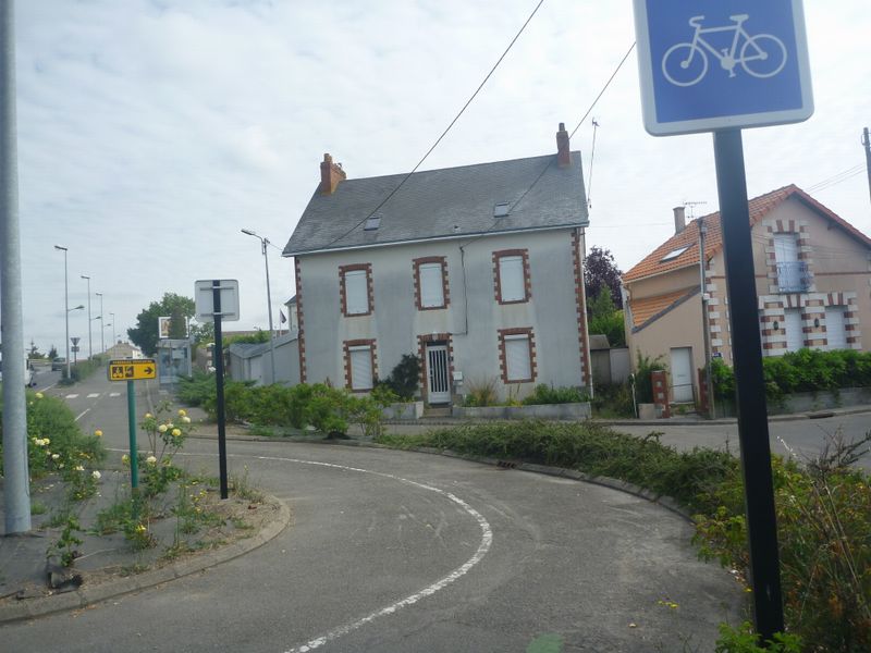 L'euro vélo six à Nantes en 2010, sillone entre routes de zone industrielles et pov' maisons anciennes perdues au milieu de la société de consomation